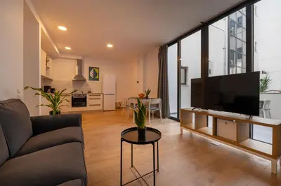a living room with a couch and a flat screen tv at ABIRA's Athens in Athens