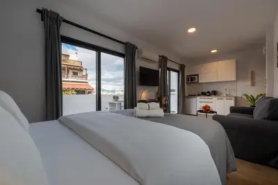 a bedroom with a white bed and a large window at ABIRA's Athens in Athens