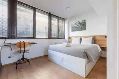a bedroom with a white bed and windows at ABIRA's Athens in Athens