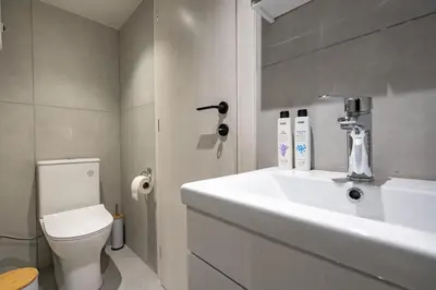 a bathroom with a white sink and a toilet at Athens Loftnest in Athens