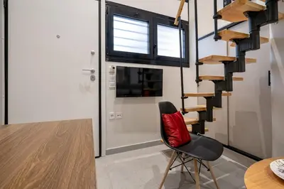 a red chair in a room with a staircase at Athens Loftnest in Athens