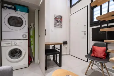 a laundry room with a washing machine and a table at Athens Loftnest in Athens