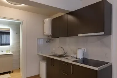a kitchen with black cabinets and a sink at Urban Athens - One Bedroom #2 in Athens