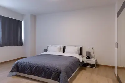 a white bedroom with a large bed and a window at Urban Athens - One Bedroom #2 in Athens