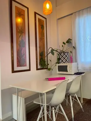 a white table with chairs and a microwave on it at Colorful Apartment Close to the Acropolis in Athens