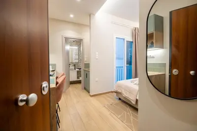 a room with a mirror and a bedroom with a bed at The Minion Elegant Suite Piraeus in Piraeus