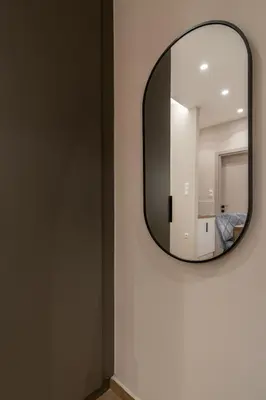 a round mirror on a wall in a room at The Minion Elegant Suite Piraeus in Piraeus