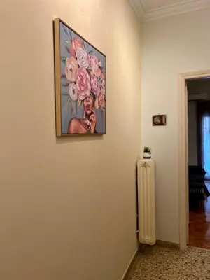 a painting of flowers on a wall next to a radiator at Yiayias home - Retro tranquility near Syntagma in Athens