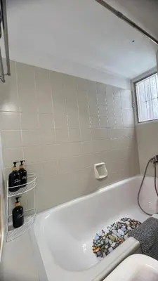 a white bath tub in a bathroom with a window at Yiayias home - Retro tranquility near Syntagma in Athens
