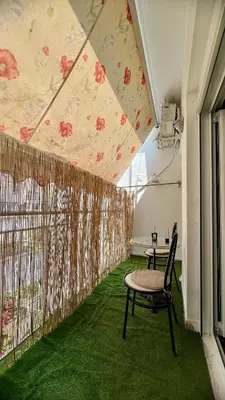 a room with a table and chairs on a green floor at Yiayias home - Retro tranquility near Syntagma in Athens