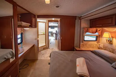 a small room with a bed and a television at ATHENS MOTORHOME park RV WINNEBAGO in Pallíni