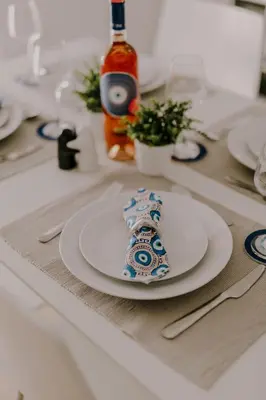 a plate on a table with a bottle of wine at Suite Home Nikaia Metro! in Piraeus