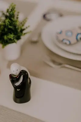a black bird figurine sitting on a table with plates at Suite Home Nikaia Metro! in Piraeus
