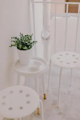 two white tables and two chairs with a potted plant on them at Suite Home Nikaia Metro! in Piraeus