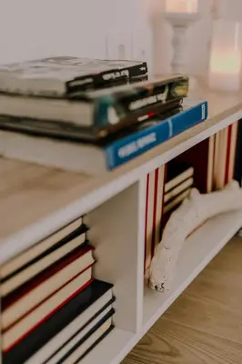 a pile of books sitting on a white shelf at Suite Home Nikaia Metro! in Piraeus
