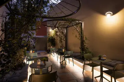 a restaurant with tables and chairs and plants at Living Yard Acropolis Apartments in Athens