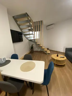 a living room with a table and chairs and a staircase at Living Yard Acropolis Apartments in Athens