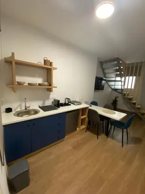 a kitchen with a sink and a table with chairs at Living Yard Acropolis Apartments in Athens