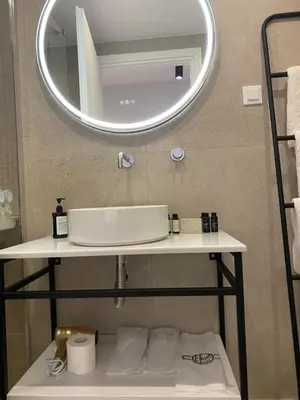 a bathroom with a sink and a mirror at Living Yard Acropolis Apartments in Athens