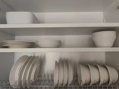 a kitchen with white plates and bowls on shelves at Center Athens all new and fully equipped 2 bedrooms 82 sqm big sea view apt close to Acropoli with Lift in Athens