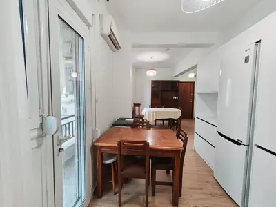 a kitchen and dining room with a table and a refrigerator at Center Athens all new and fully equipped 2 bedrooms 82 sqm big sea view apt close to Acropoli with Lift in Athens