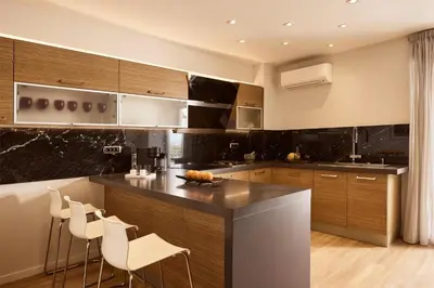 a kitchen with wooden cabinets and a counter with stools at Casa Volare, Penthouse Retreat - Athenian Riviera in Athens