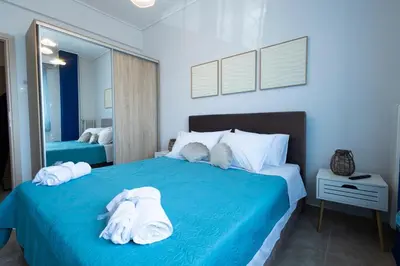 a bedroom with a blue bed with towels on it at TheJellyfishDream Sea-view Balcony Piraeus Escape in Piraeus