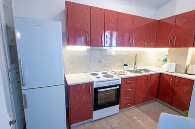 a kitchen with red cabinets and a white refrigerator at TheJellyfishDream Sea-view Balcony Piraeus Escape in Piraeus