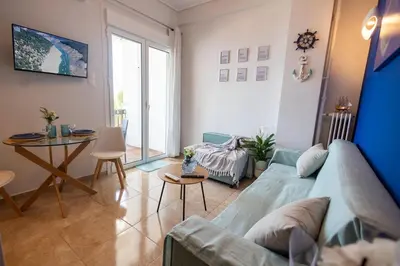 a living room with a blue couch and a table at TheJellyfishDream Sea-view Balcony Piraeus Escape in Piraeus