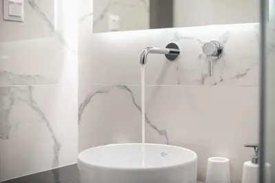 a white bathroom with a sink and a shower at Acropolis Luxurious Apartment in Athens