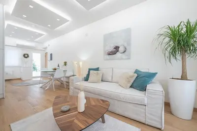 a living room with a white couch and a table at Acropolis Luxurious Apartment in Athens