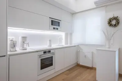 a white kitchen with white cabinets and appliances at Acropolis Luxurious Apartment in Athens