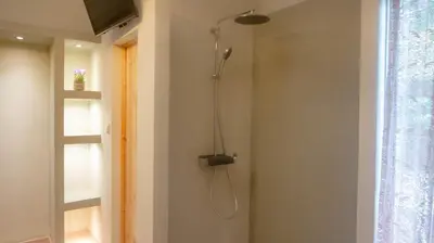 a shower in a bathroom with a shower head at The Athenian Nook in Athens