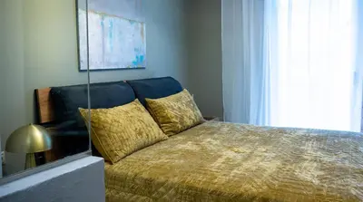 a bedroom with a bed with a gold blanket and a window at The Clay Nest in Athens