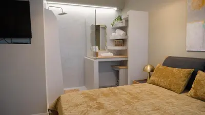 a small bedroom with a bed and a tv at The Clay Nest in Athens