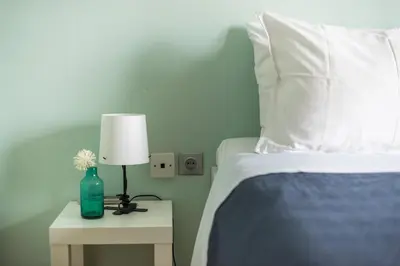 a bedroom with a bed and a lamp on a night stand at Athen's cozy home in Athens