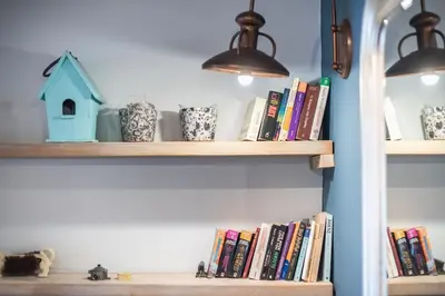 a book shelf with books and vases and lights at Athen's cozy home in Athens