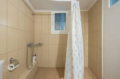 a shower curtain in a bathroom with a window at Athen's cozy home in Athens