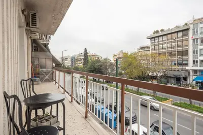 a balcony with a table and chairs and a view of cars at Athen's cozy home in Athens