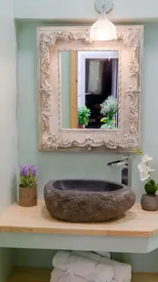 a bathroom with a stone sink and a mirror at Cozy Roots in Athens