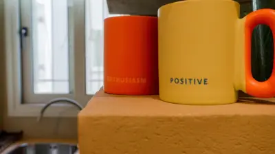 two orange and yellow cups on a counter next to a sink at Cozy Roots in Athens