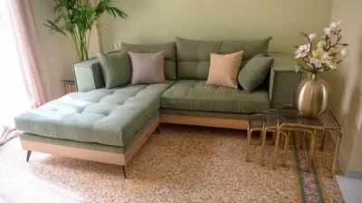 a living room with a green couch with pink pillows at The Garden Loft in Athens