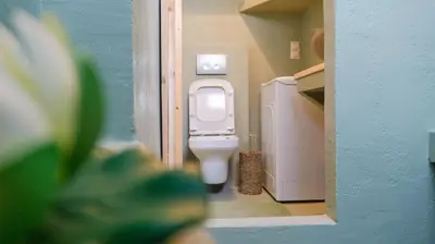 a bathroom with a white toilet in a blue wall at The Garden Loft in Athens