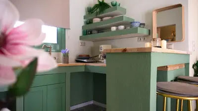 a green kitchen with a counter and a mirror at The Garden Loft in Athens