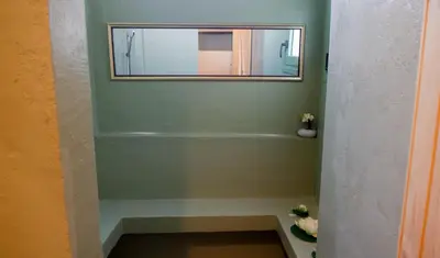 a bathroom with a mirror on a green wall at The Garden Loft in Athens