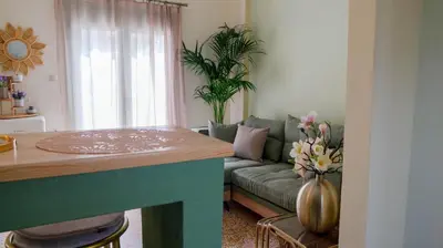 a living room with a green couch and a table at The Garden Loft in Athens