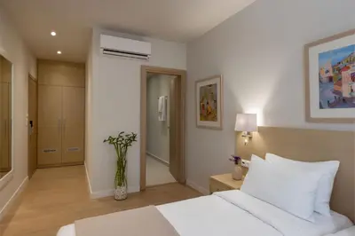 a bedroom with a white bed and a vase of flowers at Gallery Port Tower Piraeus in Piraeus