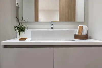 a bathroom counter with a white sink and a mirror at Gallery Port Tower Piraeus in Piraeus