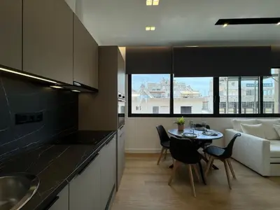 a kitchen and living room with a table and chairs at BlueMotion - Cruisenest Transportation included in Piraeus