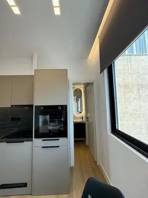 a white kitchen with a stove and a window at BlueMotion - Cruisenest Transportation included in Piraeus